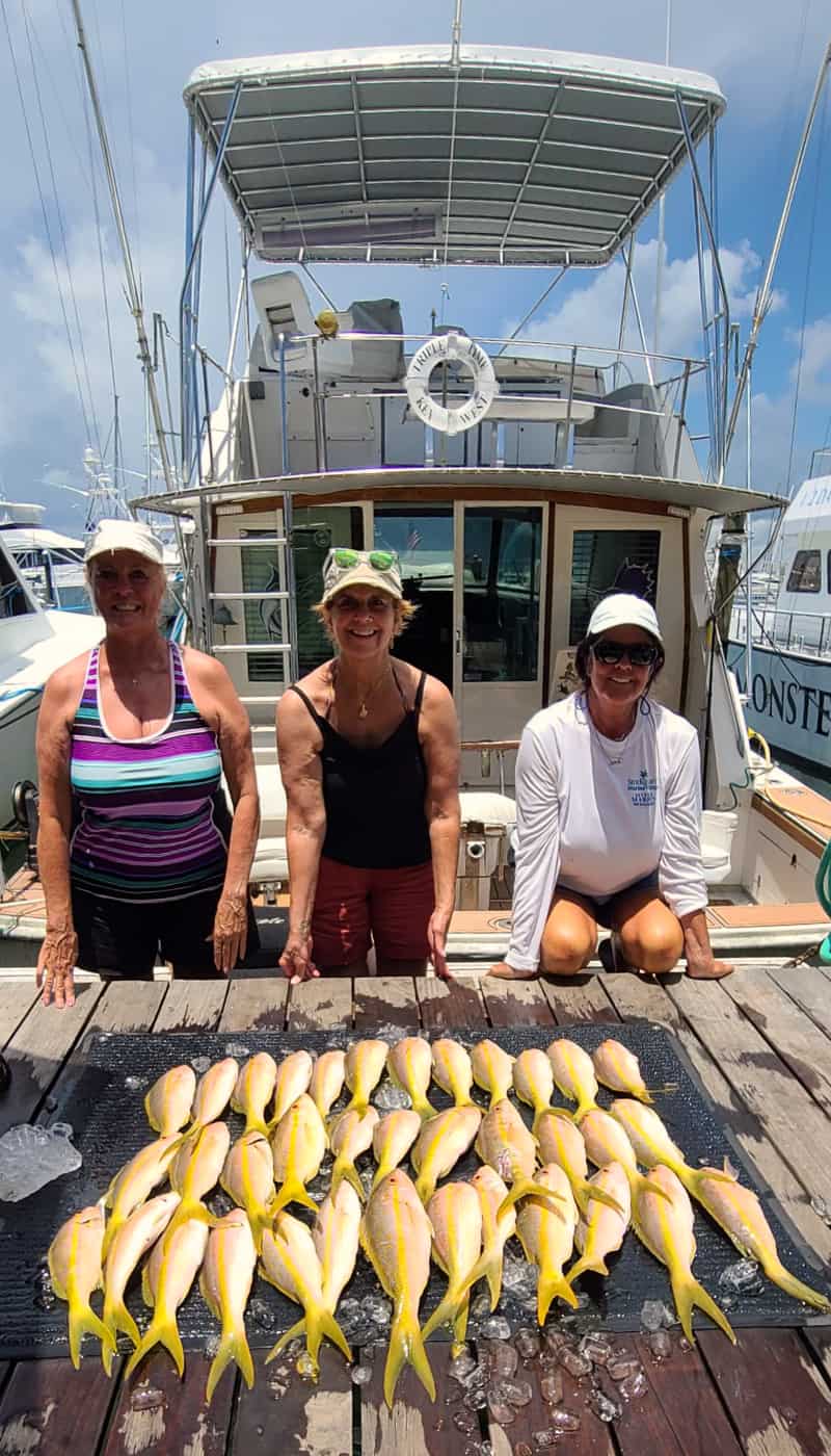 Three ladies on the dock with the yellow snapper they caught.
