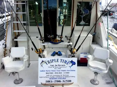 Triple Time charter boat with seats and fishing poles.